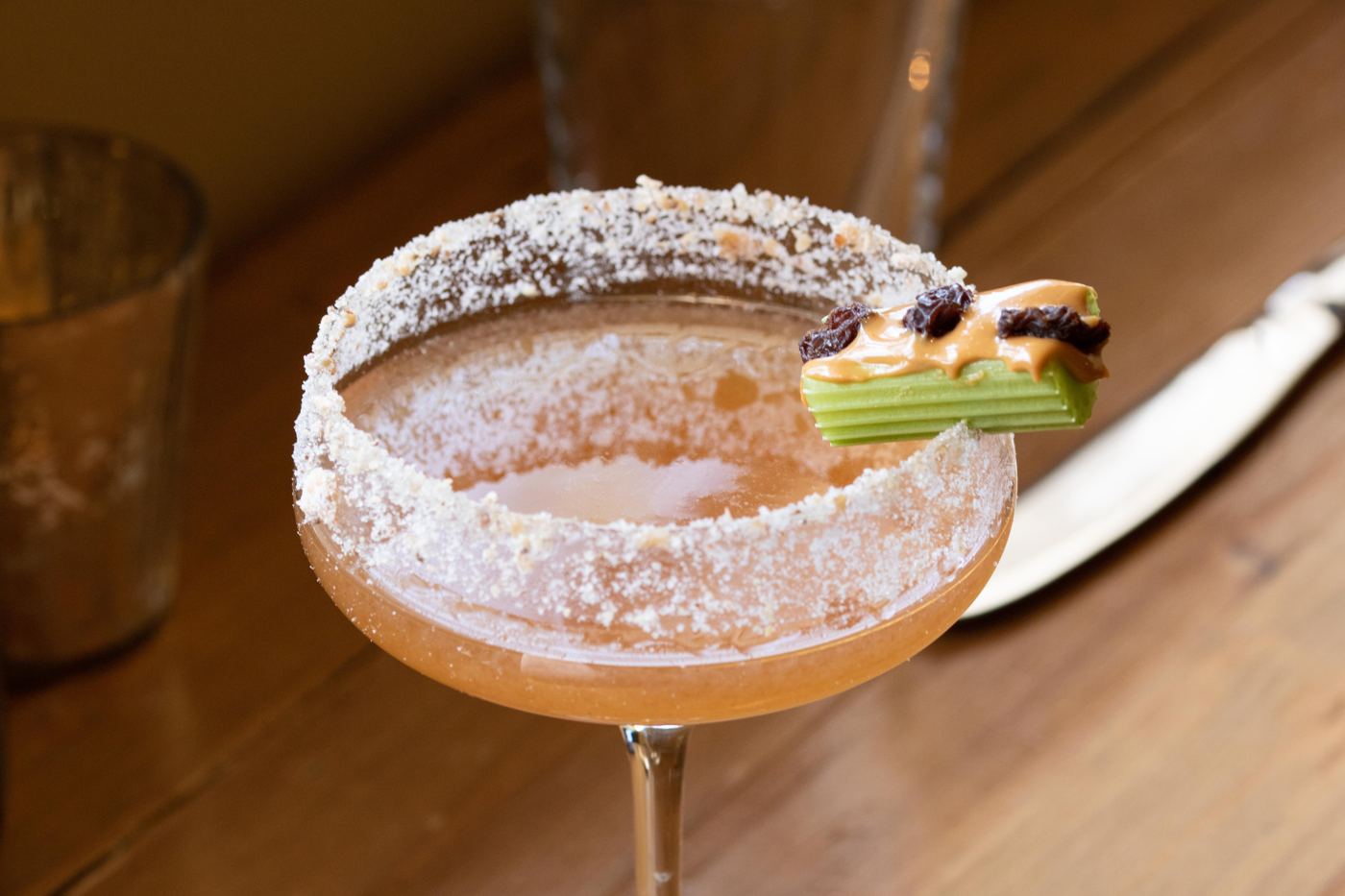 Ants on a Log cocktail with a celery, peanut butter, and raisin garnish