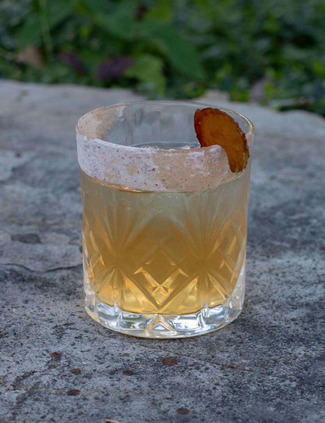 Competition tequila cocktail on the rocks with a dried fruit garnish